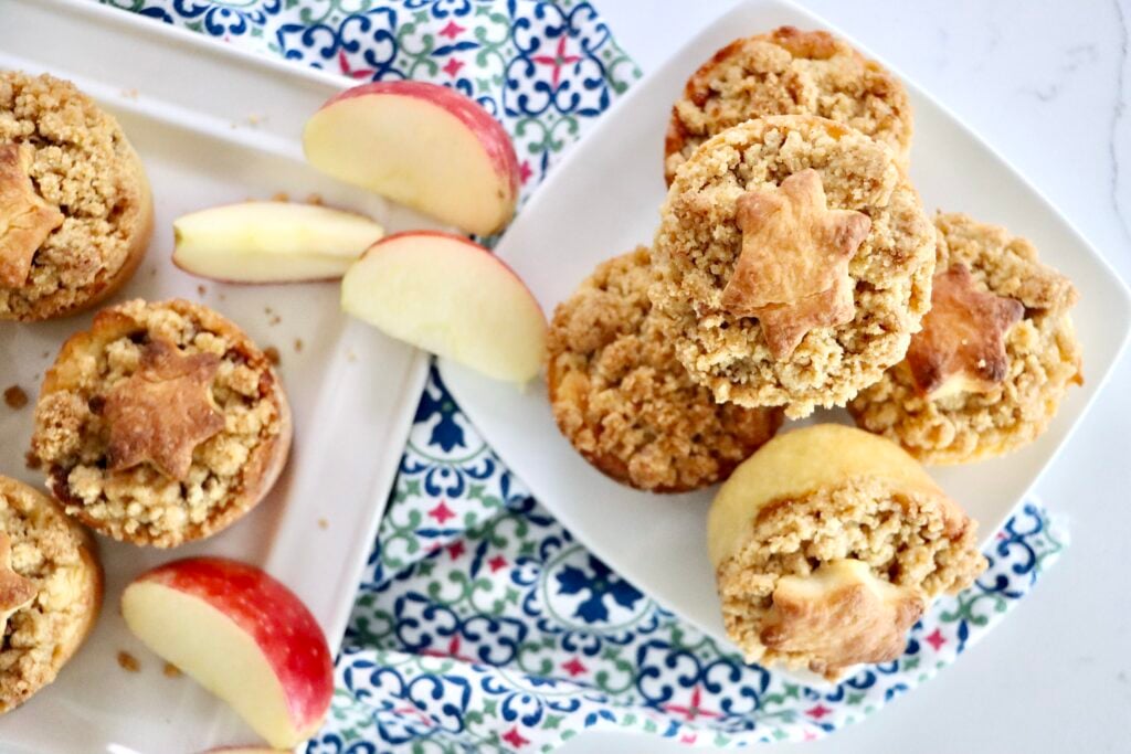 Mini Dutch Apple Pie with decorative crust shapes on top, showing soft cinnamon apple filling inside