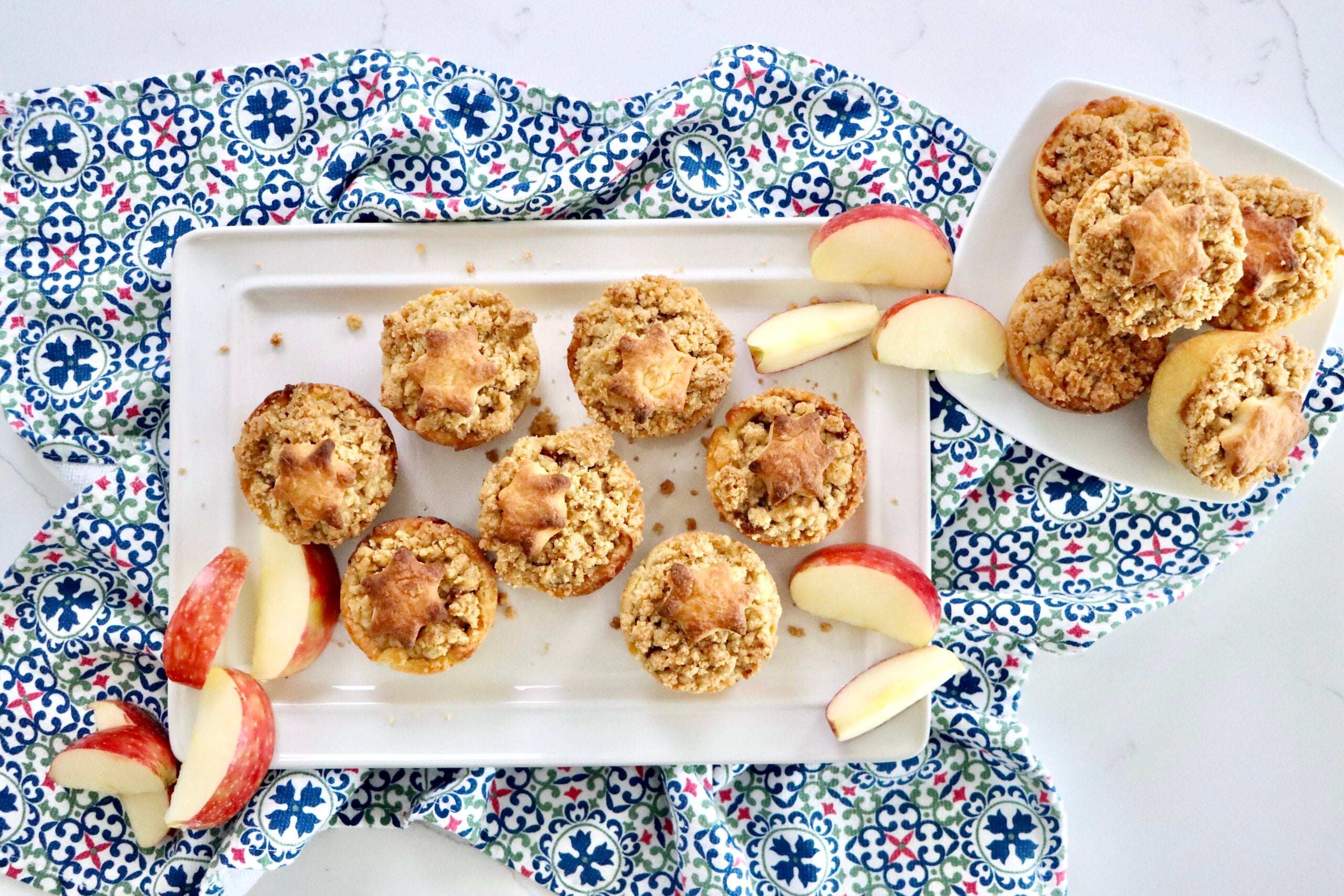 Mini Dutch Apple Pie with decorative crust shapes on top, showing soft cinnamon apple filling inside