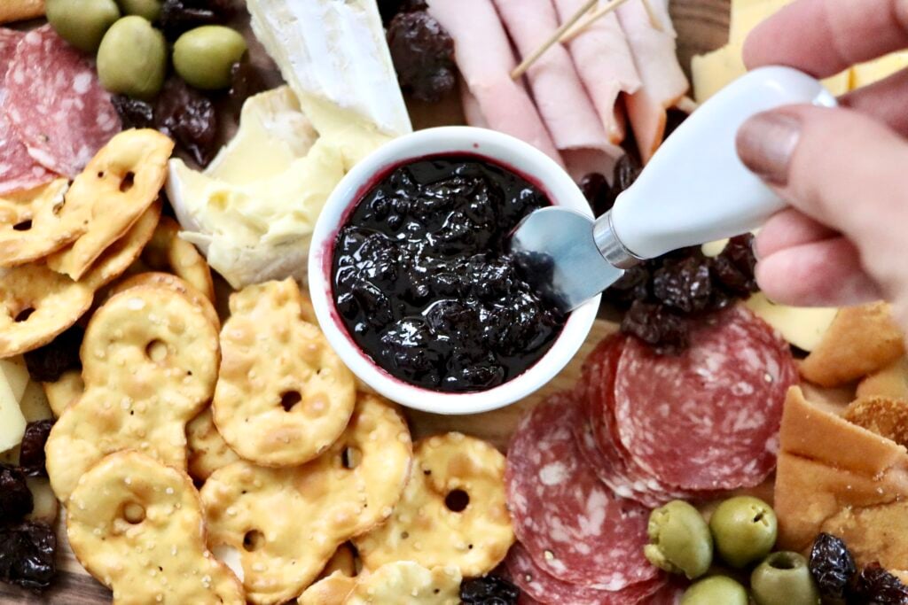 Homemade cherry jam in white dish on charcuterie board made from scratch with fresh cherries, simple small batch recipe with no pectin
