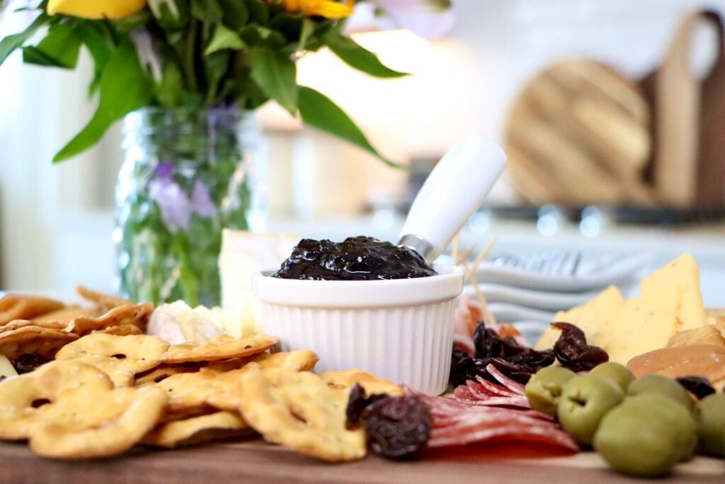 Homemade cherry jam in white dish on charcuterie board made from scratch with fresh cherries, simple small batch recipe with no pectin