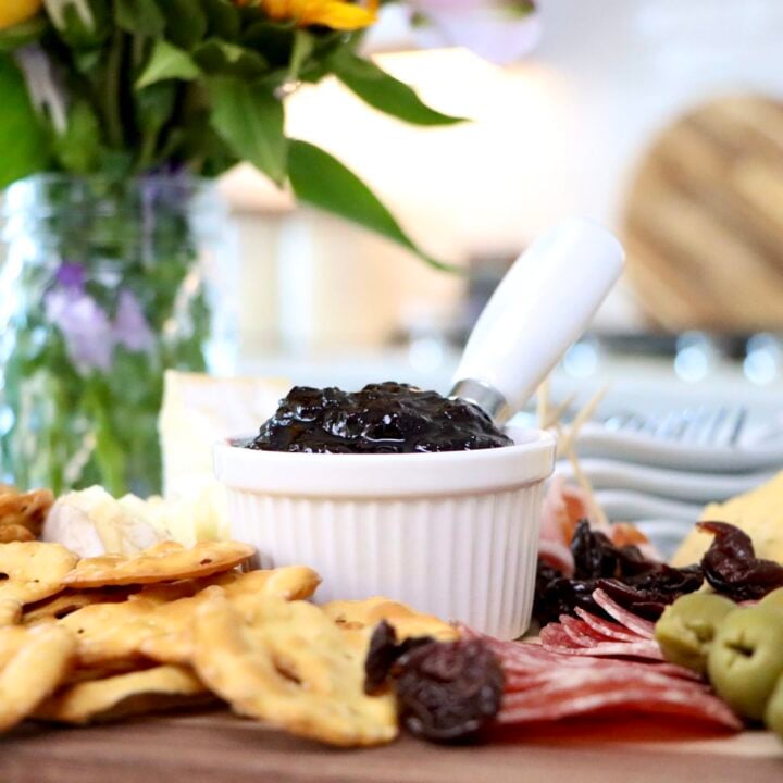 Homemade cherry jam in white dish on charcuterie board made from scratch with fresh cherries, simple small batch recipe with no pectin