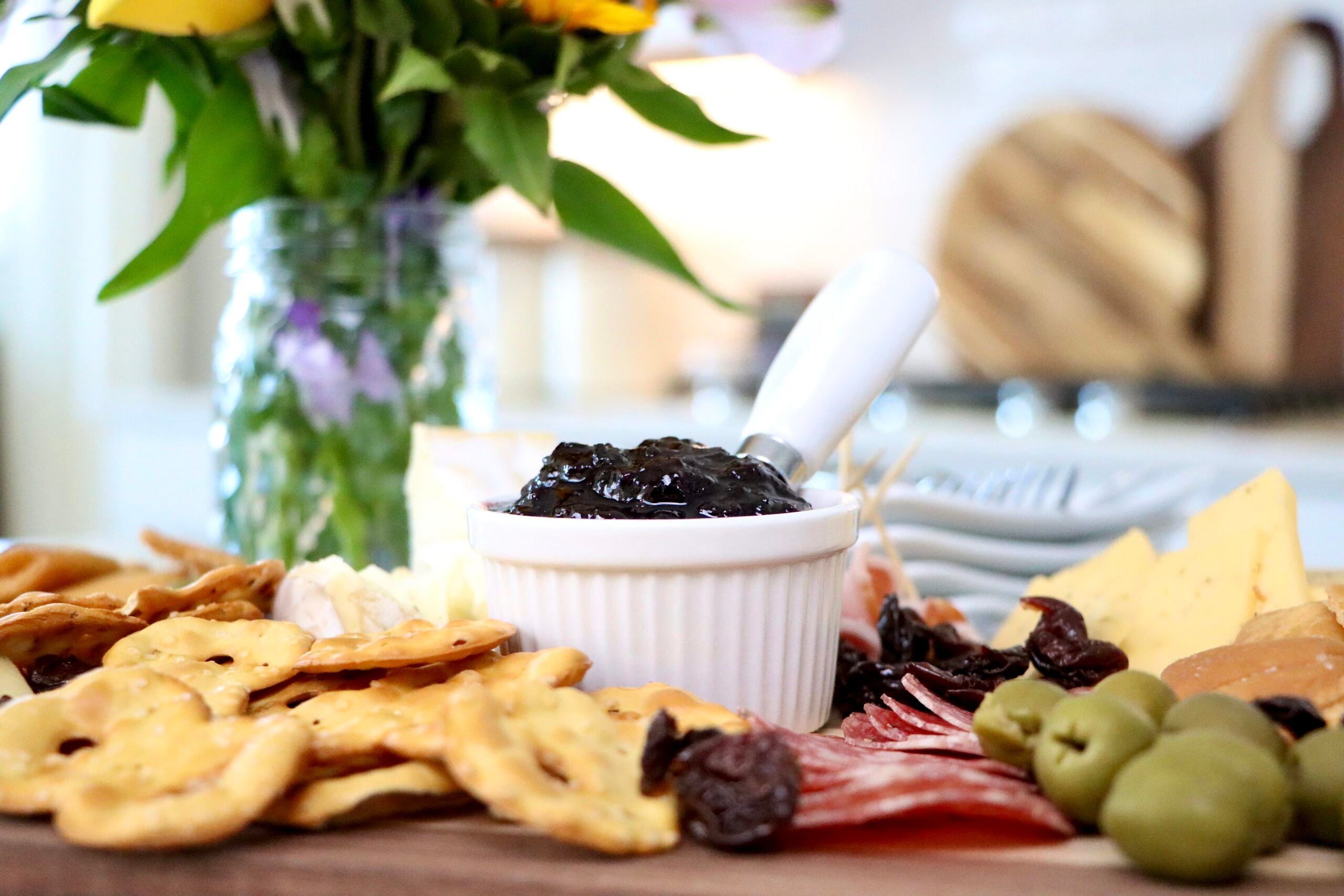 Homemade cherry jam in white dish on charcuterie board made from scratch with fresh cherries, simple small batch recipe with no pectin