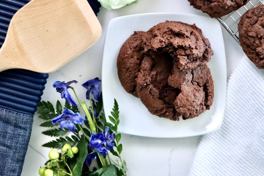 Soft and chewy chocolate chocolate chip cookies stacked with melty chocolate chips visible
