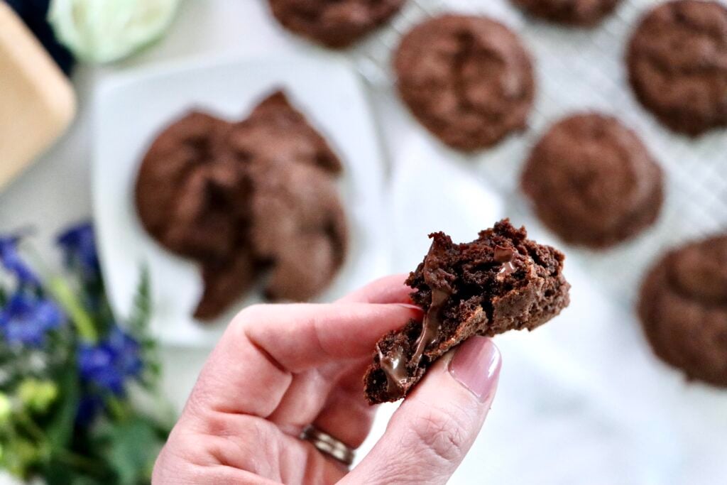 Close-up of a chocolate chocolate chip cookie broken in half showing a soft, fudgy center