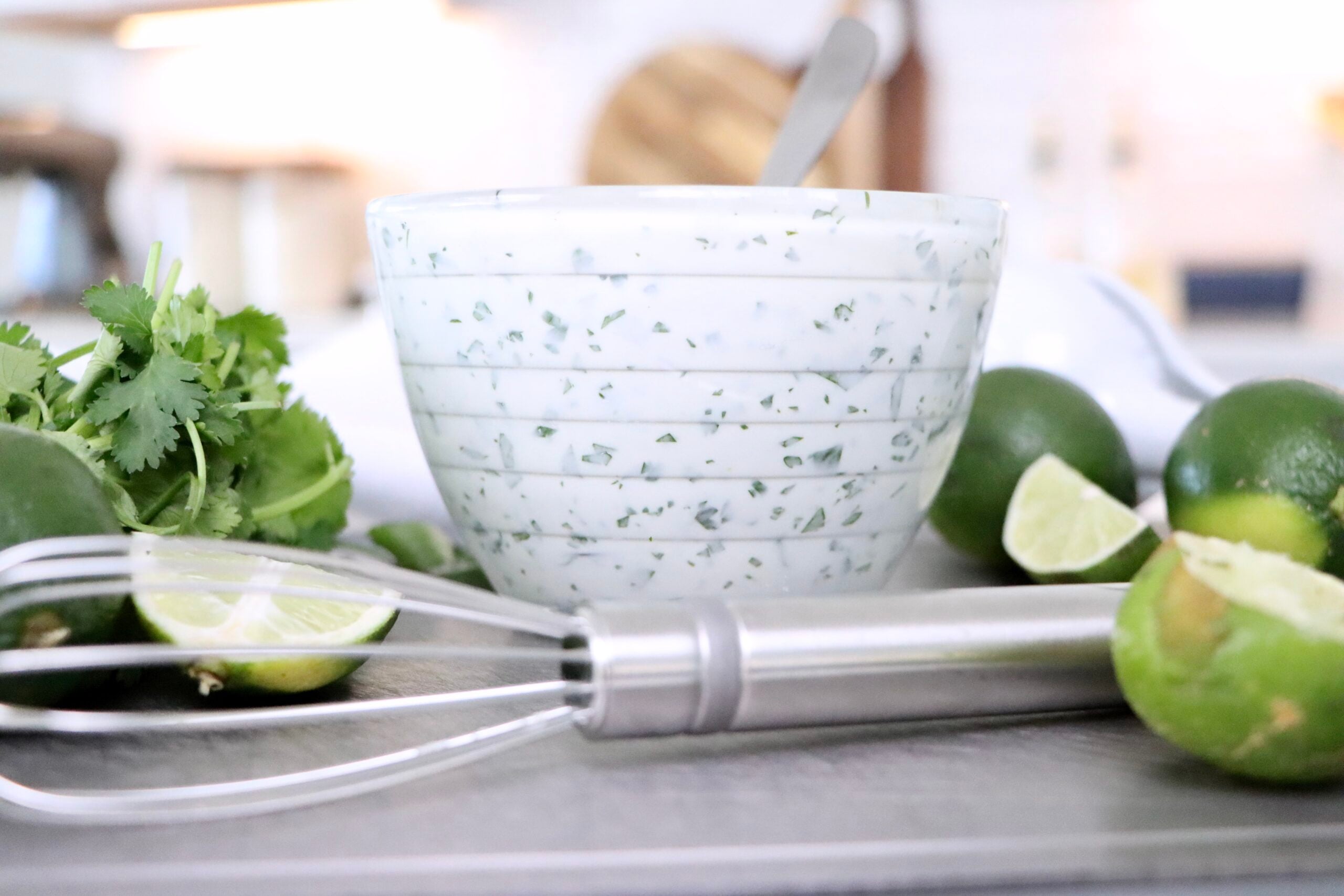 Fresh cilantro lime crema in a white bowl, vibrant green flecks of cilantro visible, perfect easy 5-minute taco sauce recipe.