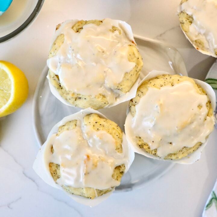 Close up of sourdough lemon poppy seed muffins topped with a sweet lemon glaze