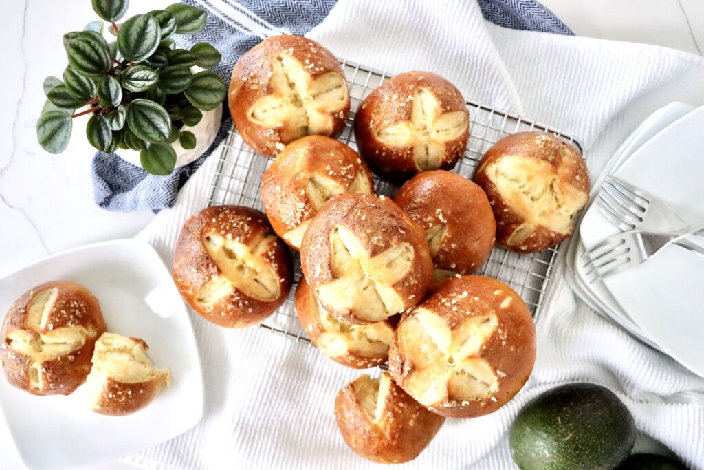 Sourdough pretzel buns stacked on a plate, perfect for burgers and sandwiches