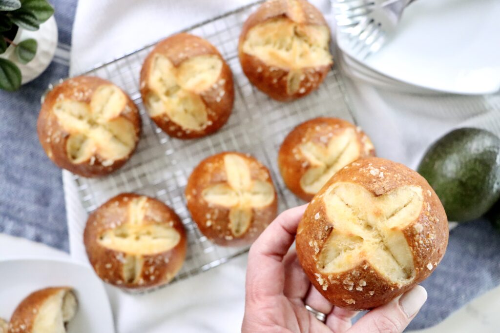 Warm sourdough pretzel buns fresh from the oven with a chewy crust and soft center