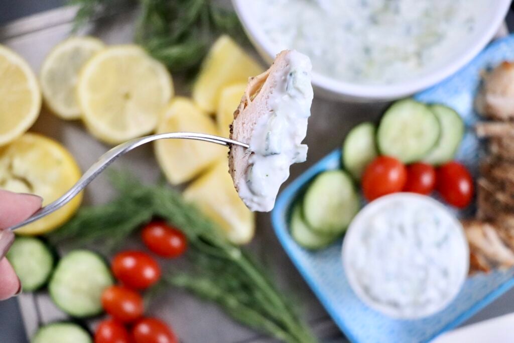 Homemade tzatziki sauce served over grilled chicken as a healthy easy dinner sauce or marinade