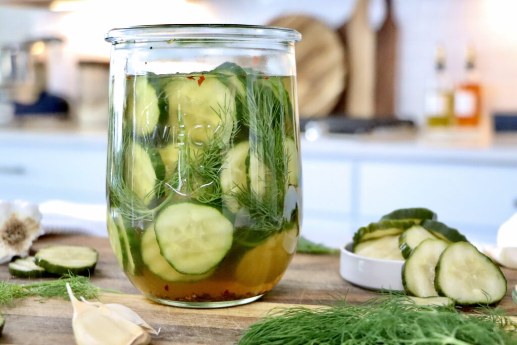 Glass jar of refrigerator dill pickles made with fresh cucumbers, herbs, and simple real ingredients.