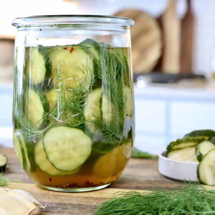 Glass jar of refrigerator dill pickles made with fresh cucumbers, herbs, and simple real ingredients.