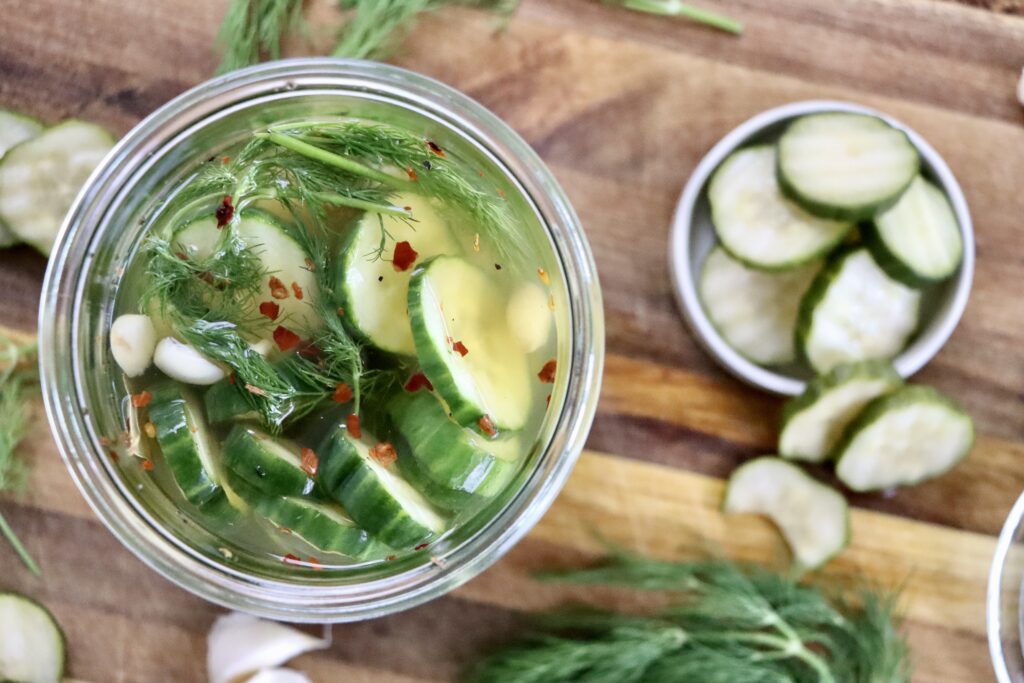 Crisp homemade refrigerator pickles with fresh cucumbers soaking in a tangy vinegar brine.
