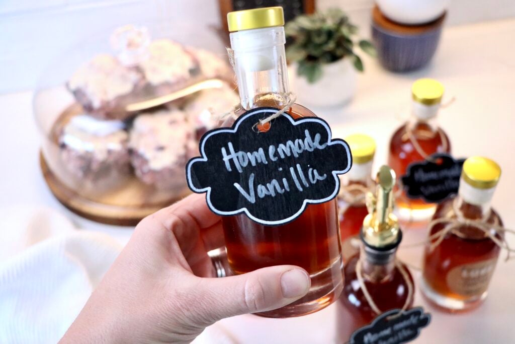 Glass bottle of homemade vanilla extract infused with vanilla beans, easy 2-ingredient recipe.
