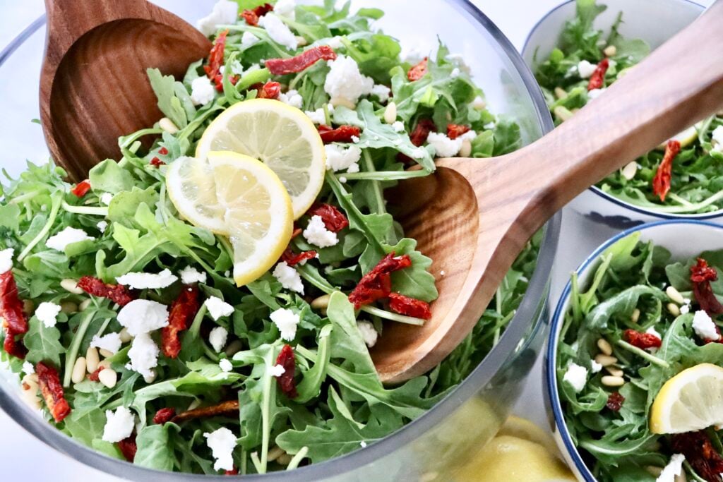 Fresh homemade arugula salad tossed with olive oil, lemon juice, goat cheese, and crunchy pine nuts.