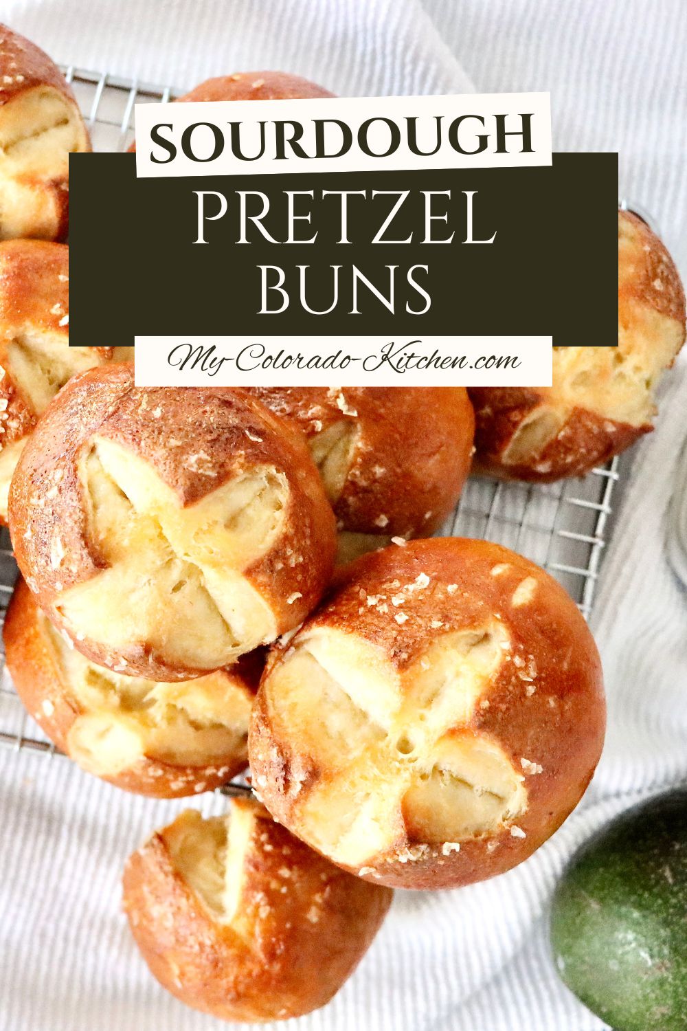 Sourdough pretzel buns stacked on a plate, perfect for burgers and sandwiches