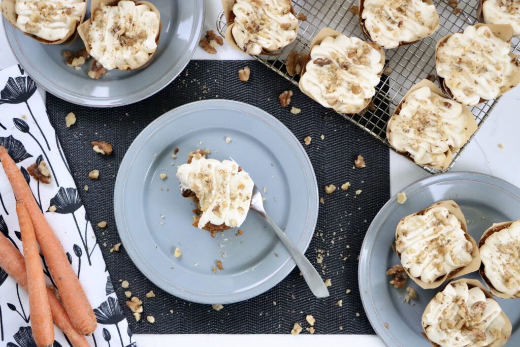 Homemade carrot cake cupcakes with rich cream cheese frosting, shredded carrots, pineapple, coconut, and walnuts