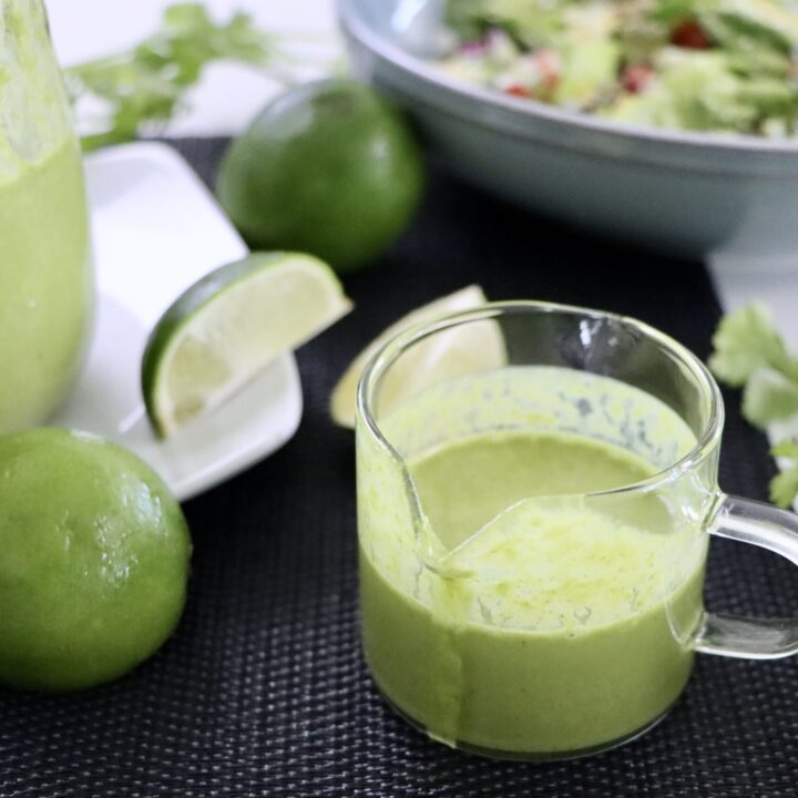 Blender-made cilantro lime salad dressing with visible fresh herbs in a smooth creamy texture.