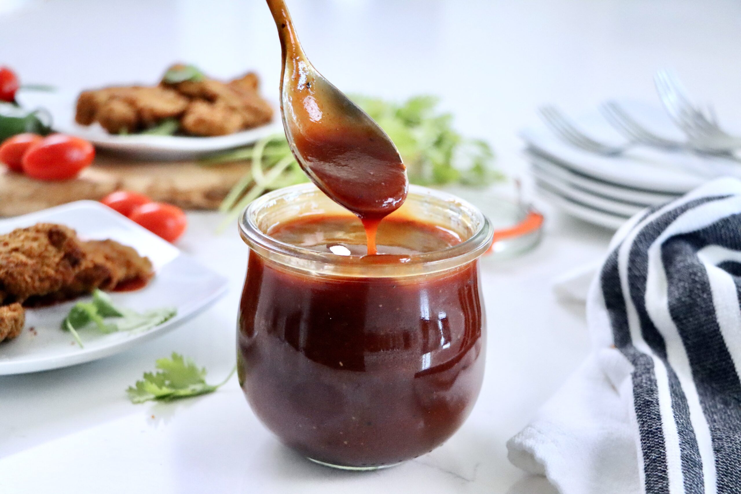 Easy homemade BBQ sauce served in a glass jar, rich in color and texture, ideal for grilled meats and sandwiches.