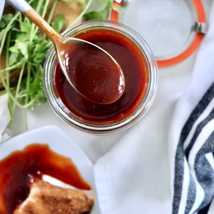 Homemade BBQ sauce in a glass jar made from ketchup, brown sugar, honey, and spices, ready to serve for grilling and dipping.