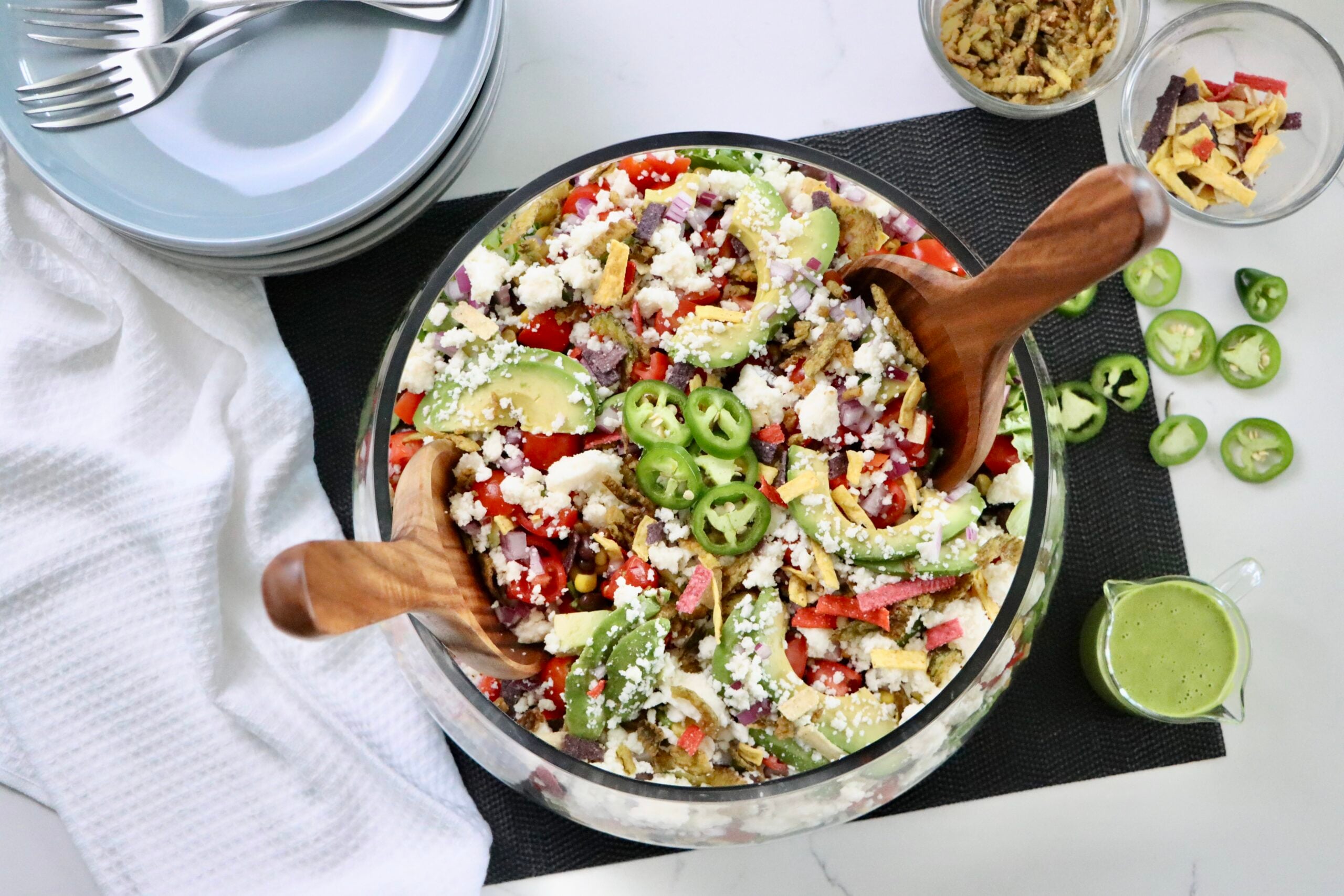 Colorful Mexican salad made with crisp lettuce, black beans, corn, avocado, and queso fresco served in a large bowl.