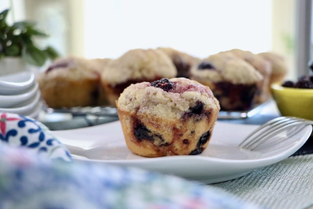 Bakery-style sourdough mixed berry muffins with tall muffin tops and mixed berries throughout.