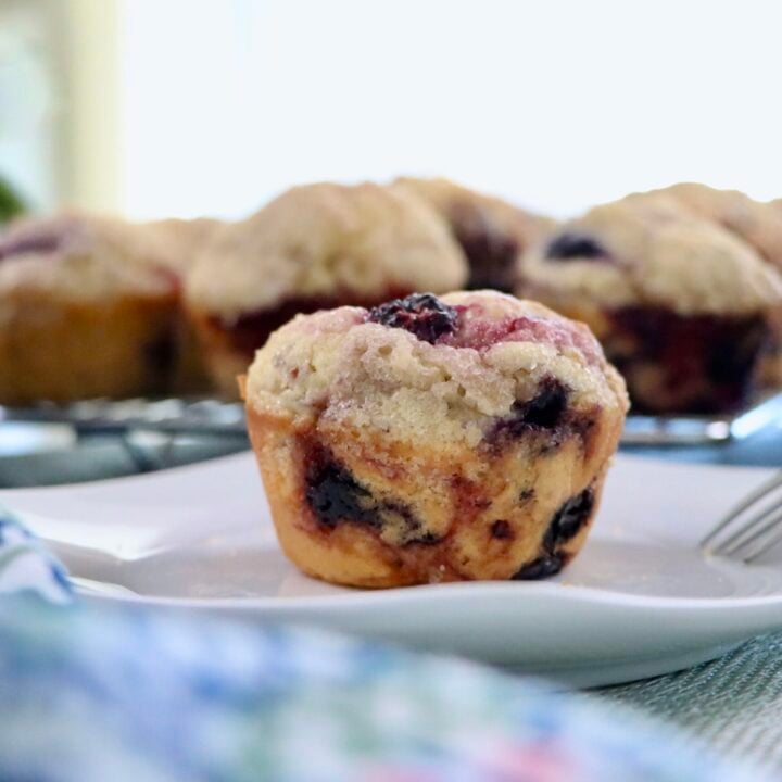 Bakery-style sourdough mixed berry muffins with tall muffin tops and mixed berries throughout.