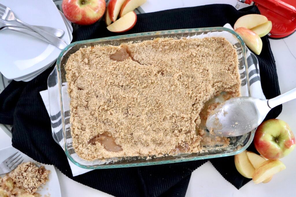 Golden apple crisp with a buttery cinnamon crumble topping in a 9x13 baking pan, fresh out of the oven