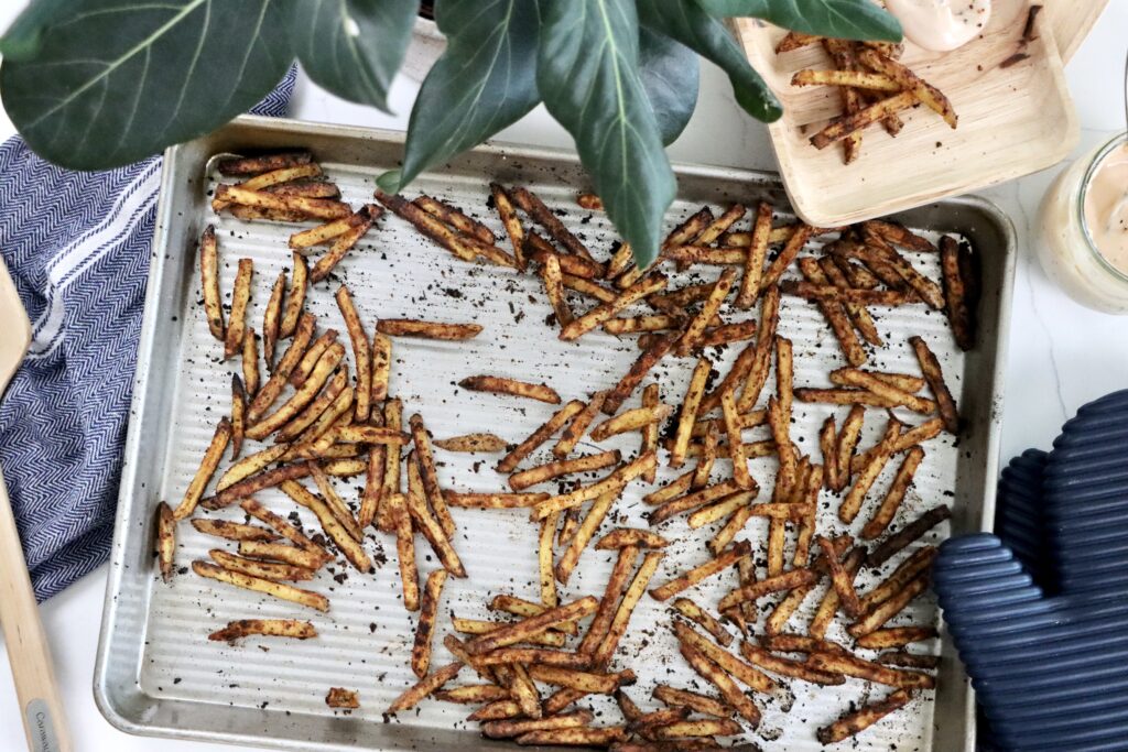 Crispy from-scratch fries cooling on a baking sheet