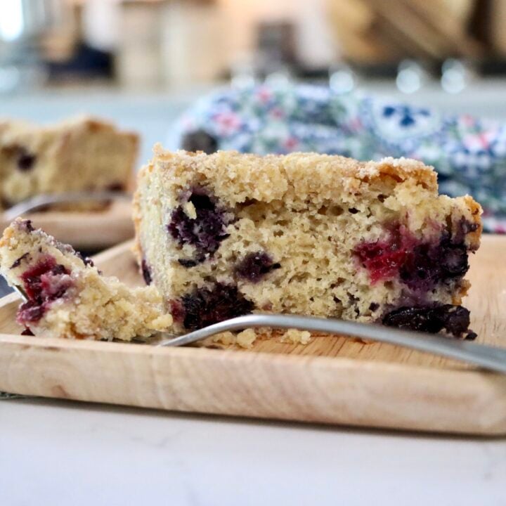 Close-up cross-section of berry crumb cake showing soft crumb, berries, and crumb topping layers