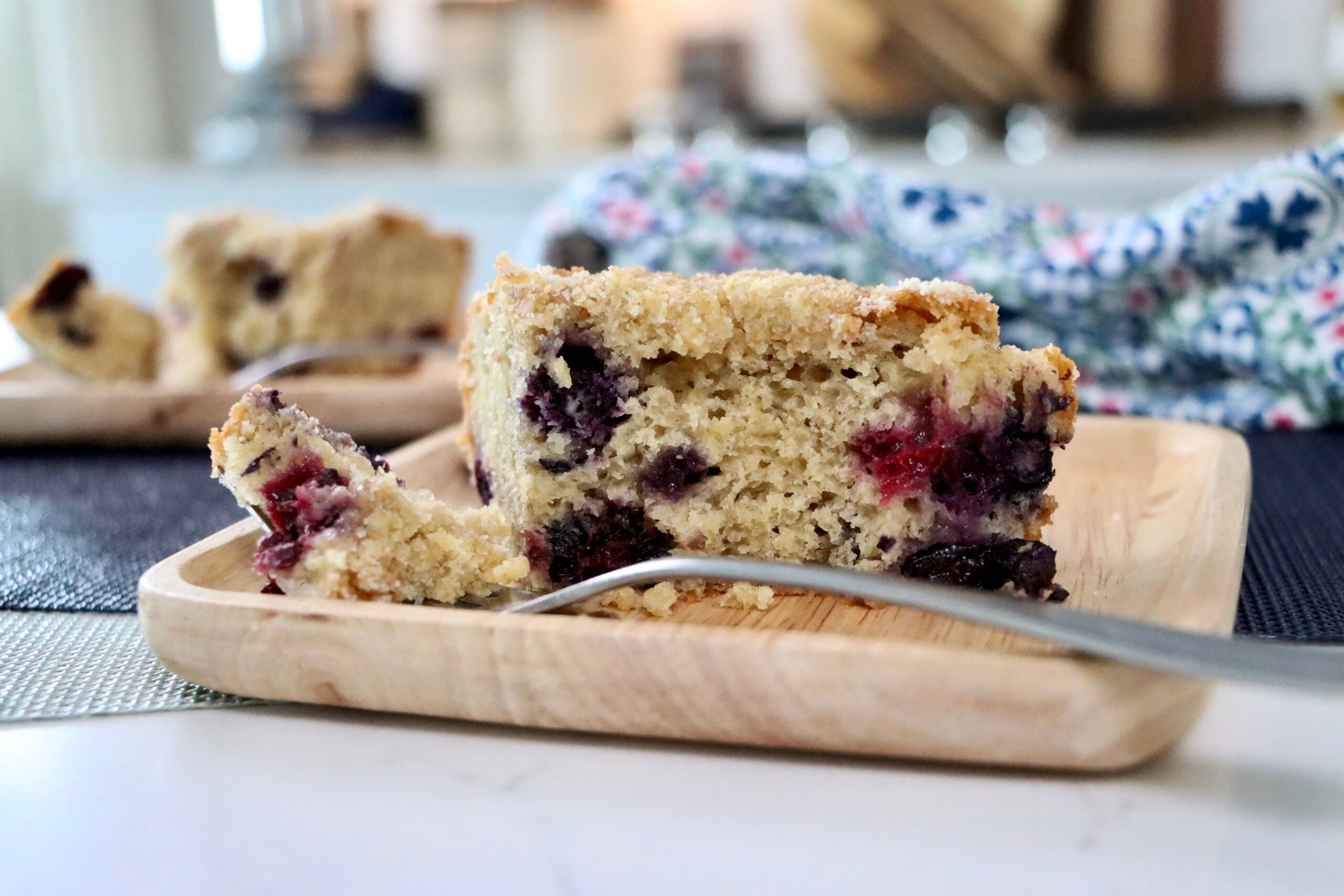 Close-up cross-section of berry crumb cake showing soft crumb, berries, and crumb topping layers