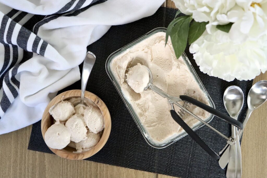A container and bowl of cinnamon ice cream