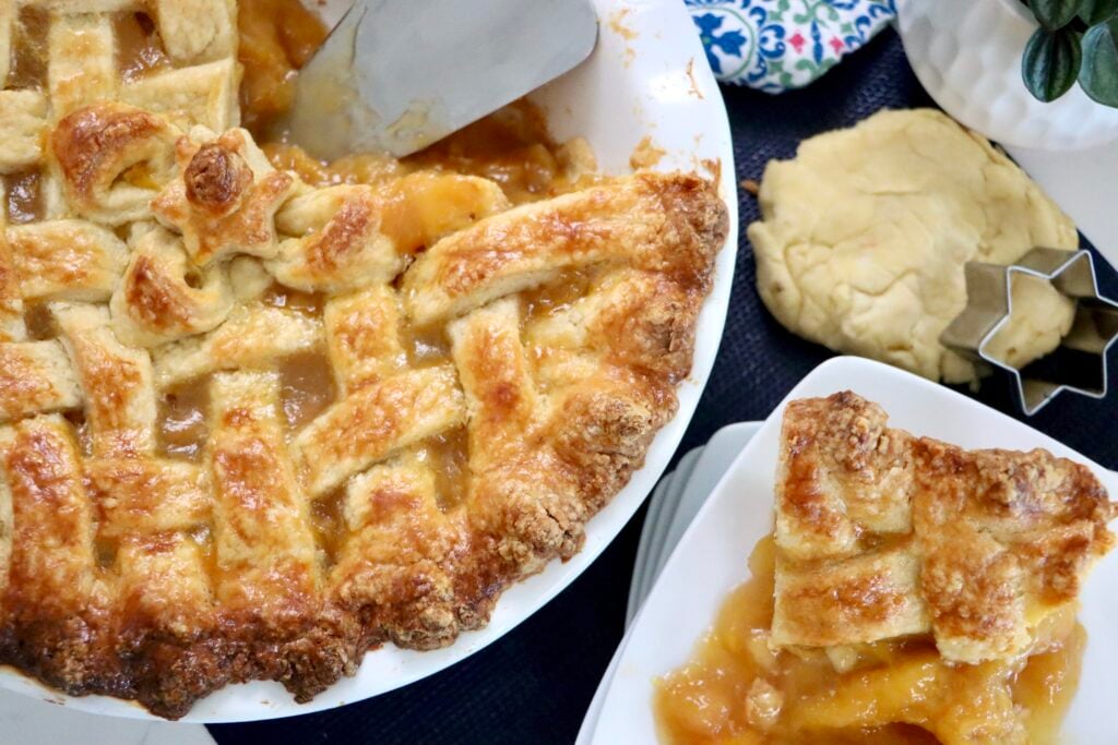 Slice of peach pie on a white plate