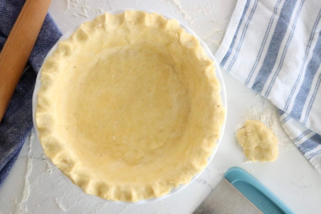 Flaky greek yogurt pie crust in a white pie plate