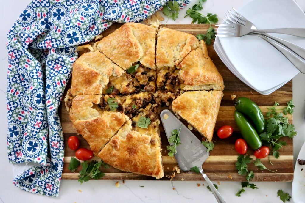 Sliced taco galette showing seasoned beef, black beans, and melted cheddar filling