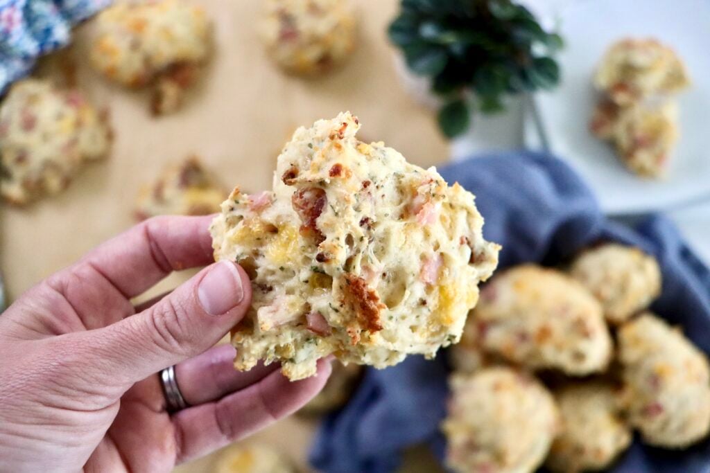 Hand holding a bacon cheddar biscuit