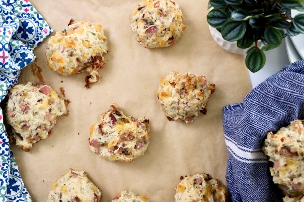 Overhead view of bacon cheddar sourdough discard biscuits on a parchment-lined pan