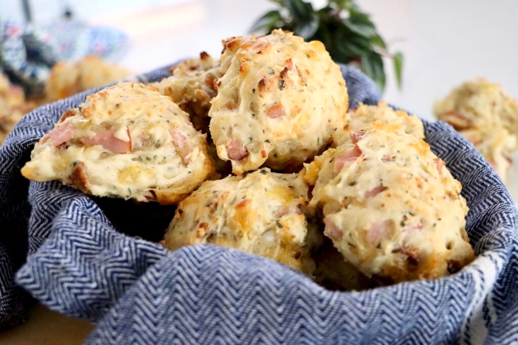 A basket of savory sourdough discard biscuits set on a wooden table