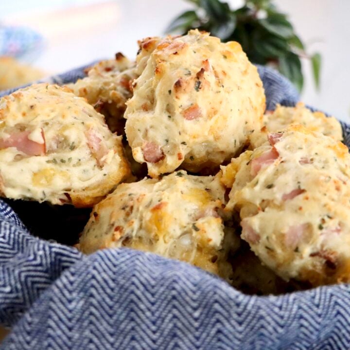 A basket of savory sourdough discard biscuits set on a wooden table
