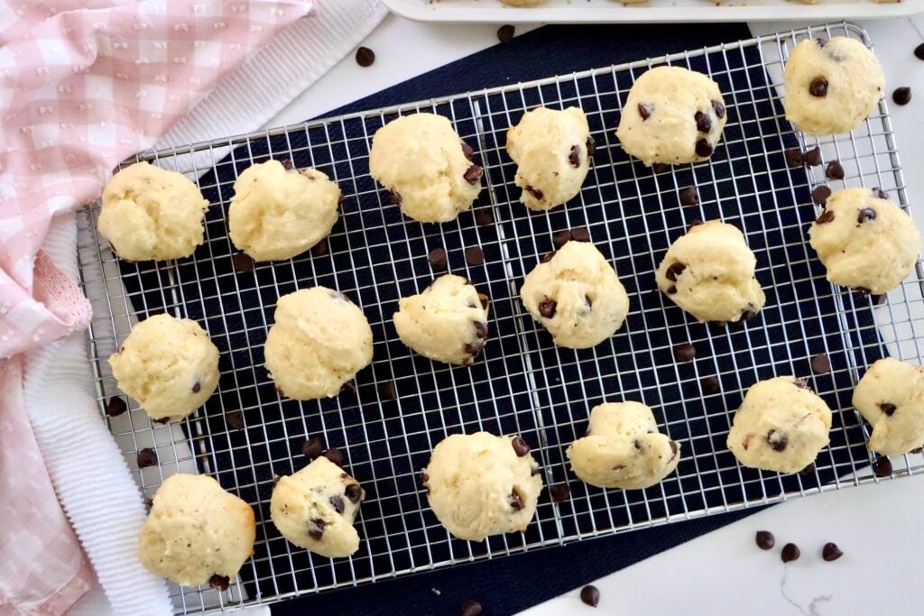 Mini chocolate chip muffins with domed bakery-style tops cooling on a wire rack