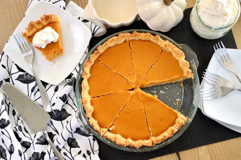 Overhead shot of pumpkin pie with one slice removed, showing silky filling