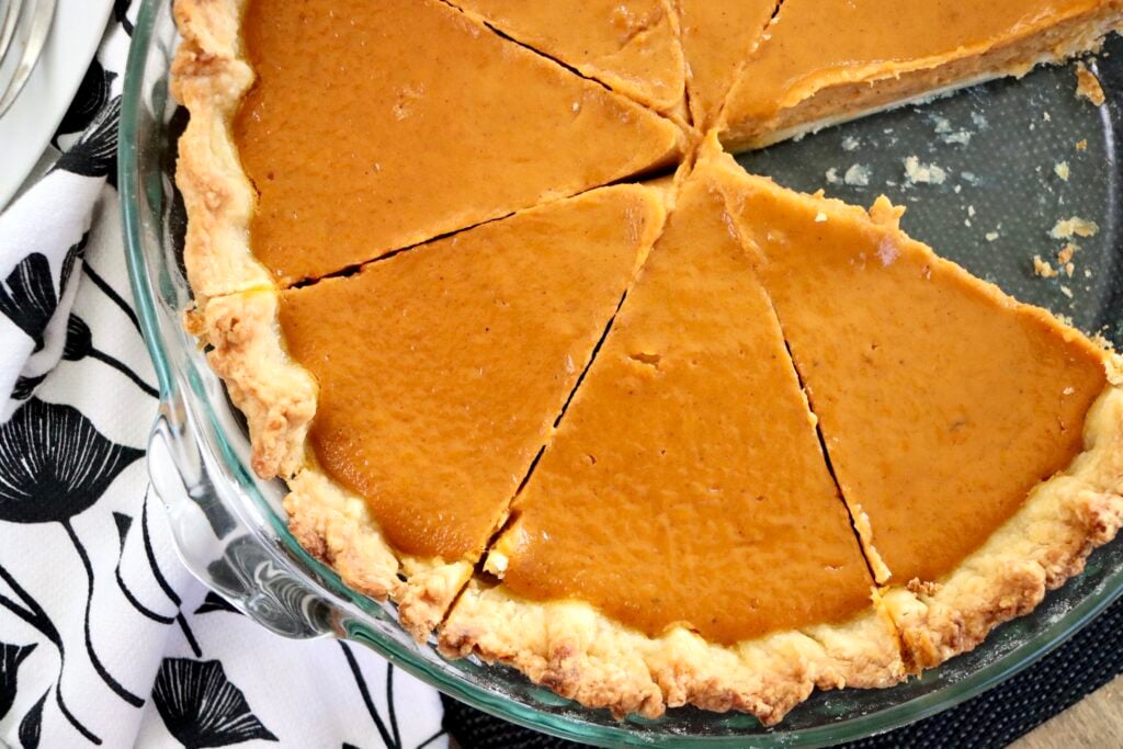 Overhead shot of pumpkin pie with one slice removed, showing silky filling