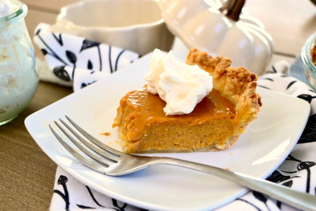 Pumpkin pie topped with a dollop of homemade whipped cream